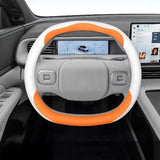 XPENG G6 Anti Slip Leather Steering Wheel Covers in white and orange, fitted on electric vehicle steering wheel.