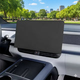 Protective matte black screen cover installed on electric vehicle's central navigation display with city park view outside.