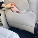 Beige car seat-back organiser with a hand placing a pink smartphone into its storage pocket