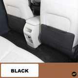Black seat back covers fitted behind white front seats, with protective panels and storage pockets in a vehicle interior