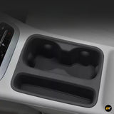 Black car centre console cup holder and storage tray with dual cup recesses and integrated lower compartment