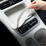 Hand fitting a white protective centre console tray liner around an automatic gear selector in a car interior