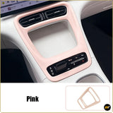Pink centre console trim cover surrounding the storage compartment and gear selector in a modern car interior