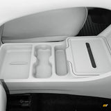 Vehicle centre console with moulded storage compartments, cup holder recesses and a covered compartment beside a leather seat