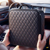 Quilted black car organiser bag with sturdy handles held inside a modern vehicle interior
