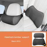 Black car headrest and lumbar support cushions fitted to white vehicle seats for added driving comfort