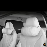 Light grey car seat neck cushions fitted to the front seats for added head and shoulder support inside a vehicle interior