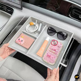 Grey divided car centre console organiser tray holding sunglasses, charging cable, cosmetics and phone in a vehicle interior