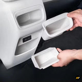 White car interior storage trays being fitted into rear console compartments for organised vehicle storage
