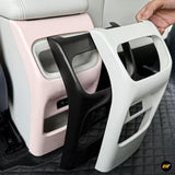 Black and white vehicle interior trim panels displayed against a pink car door and cream leather seat