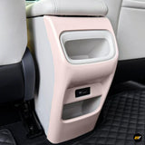 Pink rear car centre console with upper storage compartment, lower pocket and USB charging port between white seats
