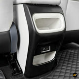 Black and white rear seat centre console with open storage compartment and USB charging port above a quilted floor mat