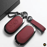 Red leather-style car key fob covers with chrome trim, key rings and matching wrist strap on a white background