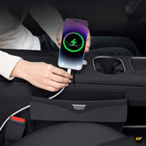 Smartphone charging by cable beside a black car centre console organiser with cup holders