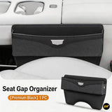 Black seat gap organiser fitted between vehicle seats, featuring a front storage pocket and silver accent detail