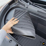 Black moulded front boot liner being placed inside an electric vehicle frunk for added cargo area protection