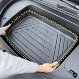 Black car boot liner with raised edges and textured grooves fitted inside a vehicle luggage compartment