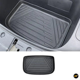 Black rubber vehicle floor mat with raised edges and geometric tread pattern, shown fitted in a footwell and separately on white background