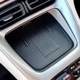Black rubber lined car centre console storage tray beneath dashboard air vents