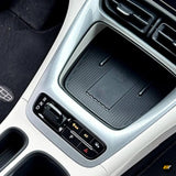 Close up of a modern car centre console with automatic gear selector, storage tray, drive mode buttons and cup holders