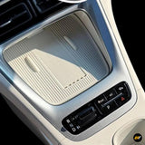 Car centre console with textured rubber storage tray, rotary gear selector, parking button and climate control switches