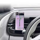 Smartphone mounted on car dashboard showing navigation map and route details in a modern electric vehicle interior