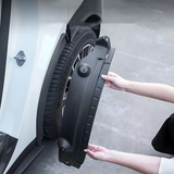 Person installing black rear mud flap splash guard on white electric vehicle wheel arch for Zeekr 7X.