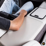 Close-up of a light grey protective cover on a car armrest with a person resting their arm on it