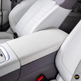 White leather armrest box protective cover on electric vehicle centre console between front seats