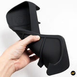 Hand holding flexible black silicone storage box designed for behind a vehicle navigation screen accessory