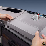 Hands installing light grey storage box behind navigation screen in electric vehicle interior with speaker grille visible