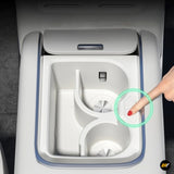 Centre console cup holder insert in light grey with adjustable compartments and finger pressing a button on the side