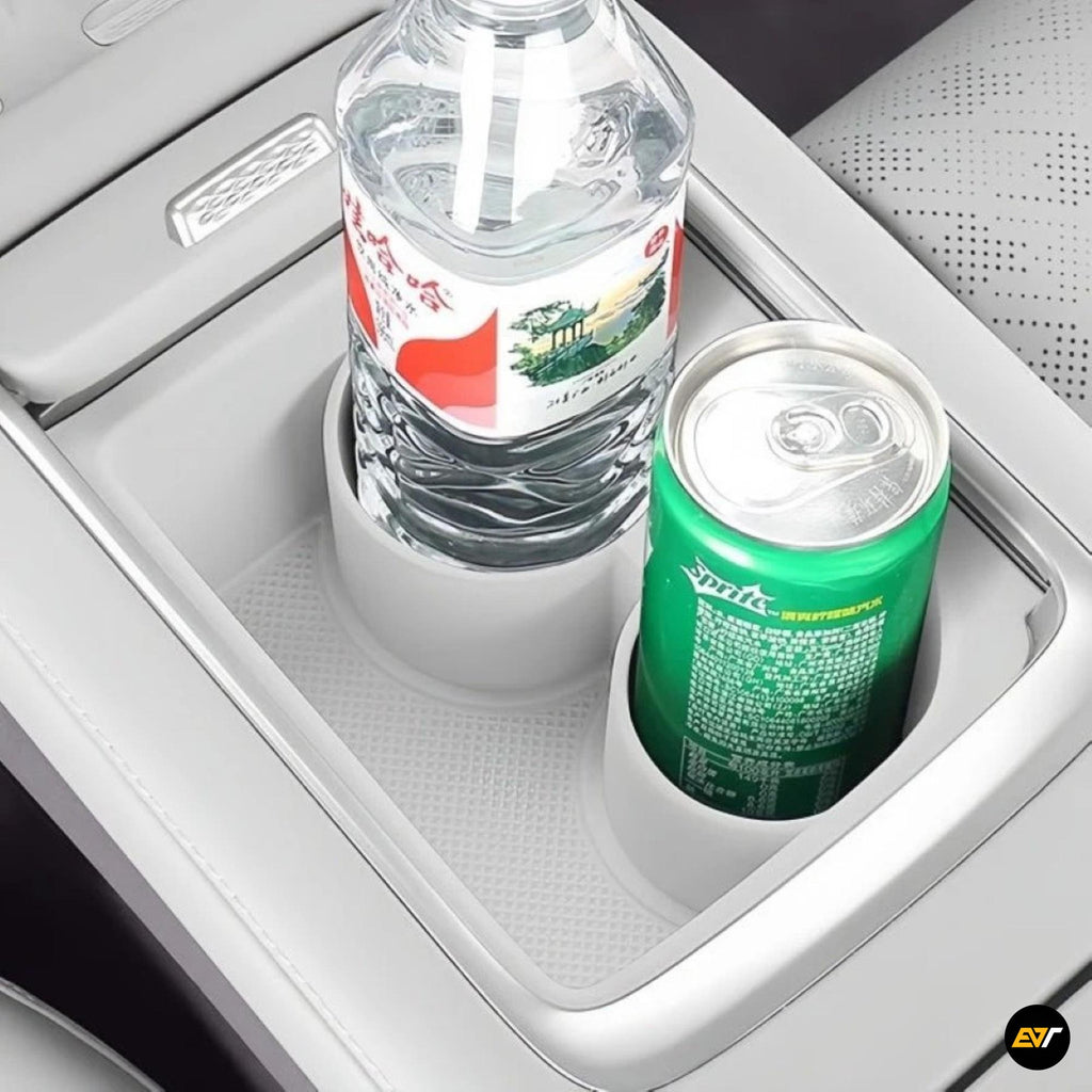 Electric vehicle centre console cup holder insert holding a plastic bottle and aluminium can in grey interior trim