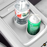 Electric vehicle centre console cup holder insert holding a plastic bottle and aluminium can in grey interior trim