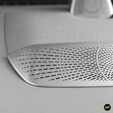 Silver metallic centre console dashboard air vent cover with a patterned grille detail for electric vehicles