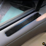 Close-up of black air vent protection cover installed on grey car door interior panel near window controls