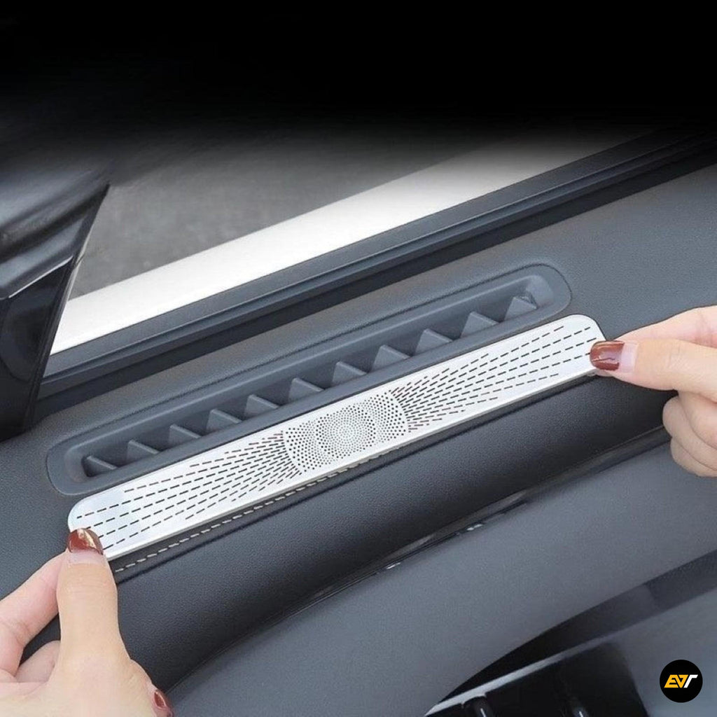 Hands installing silver air vent protection cover on electric vehicle black door panel interior
