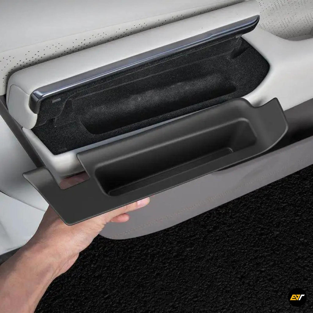 Hand opening black storage box integrated into front car door panel with light grey interior trim