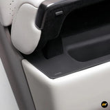 Close-up of a car door panel showing white leather and a hidden storage compartment with a soft-touch black interior lining.