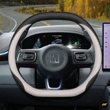 Premium leather steering wheel cover in black and white with textured grip on an electric vehicle dashboard