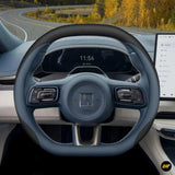 Premium leather steering wheel cover in grey and black with stitched detailing on an electric vehicle dashboard