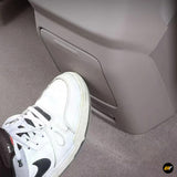 Close-up of white sneaker near the rear exhaust air outlet frame cover inside a vehicle interior panel