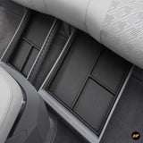 Underseat black storage organisers fitted beneath the second-row seats in a modern car interior.