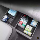 Underseat storage organisers in car second row holding bottles, tissue box, wet wipes, and drink containers.