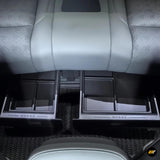Underseat storage organisers installed beneath the second row grey leather car seats in electric vehicle interior