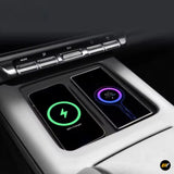 Two smartphones wirelessly charging side by side on a car centre console with chrome buttons above